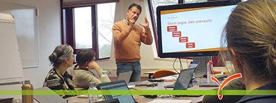 Man staat voor groep deelnemers aan training time management